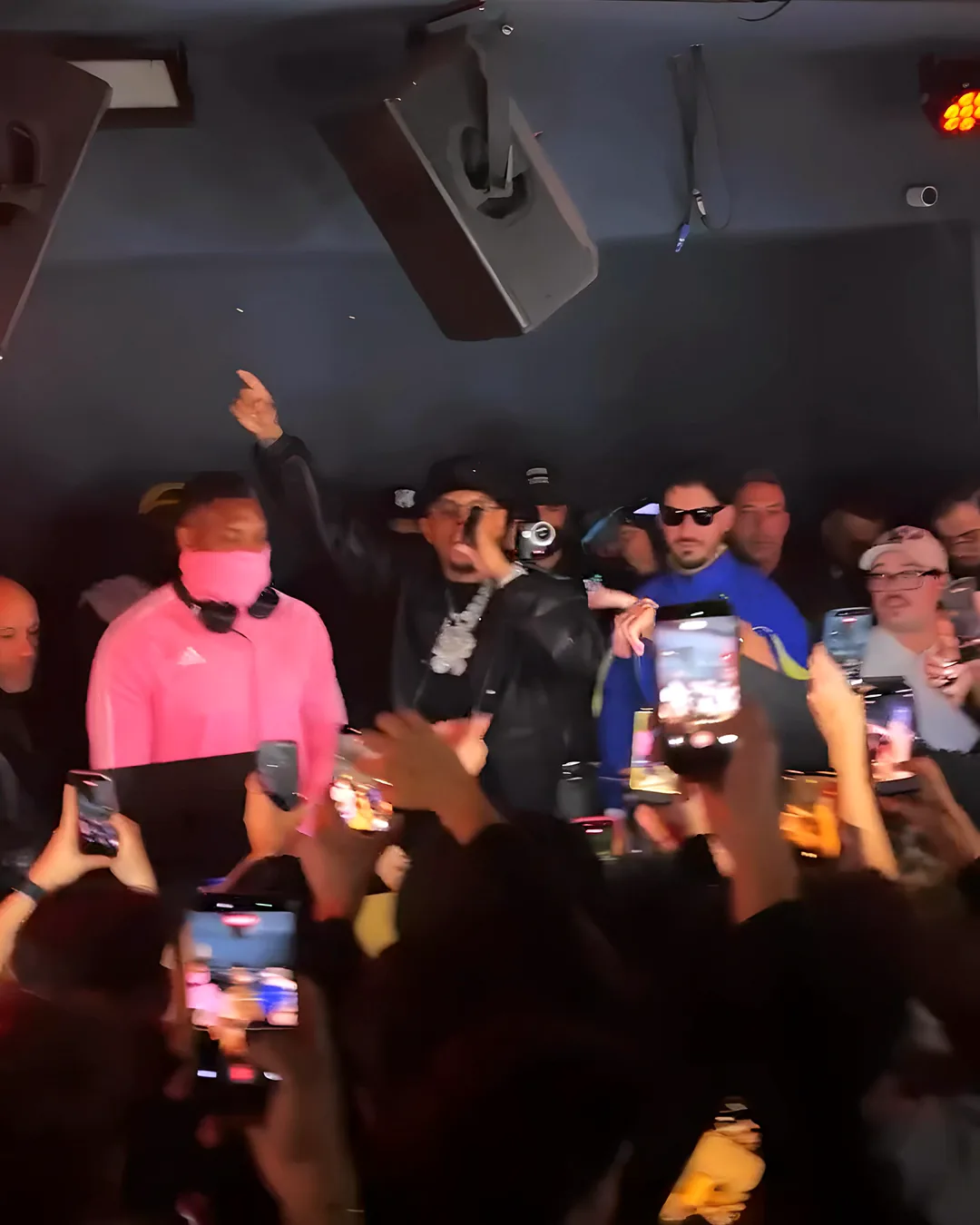 DJ King Halim in Pink am Pult im VIE I PEE, daneben die Bühne, davor die Handys der Crowd